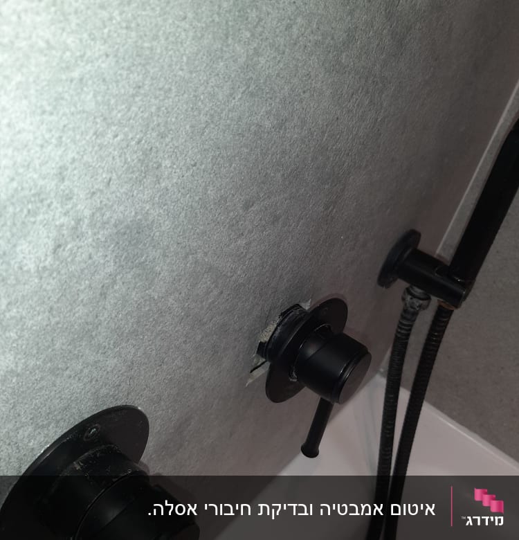 ברזים שחורים על קיר אפור בחדר אמבטיה